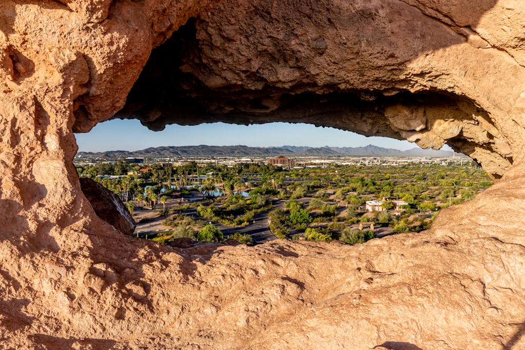 7 Hidden Spots Near Cactus League Ballparks 2 Capture of Phoenix cityscape through a unique rock formation in Papago Park, Arizona.